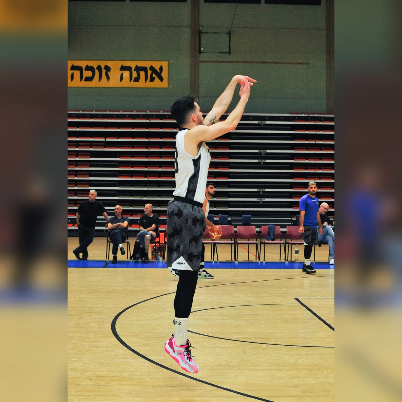 מתן בסיום זריקה במשחק ליגה, יציע מלא ברקע
